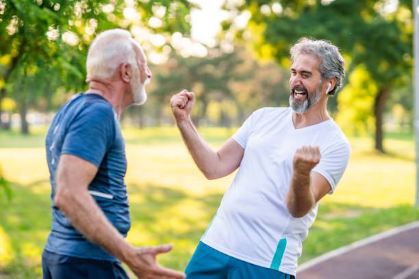 istock Smiling senior athletes jogging in the park 1169621834