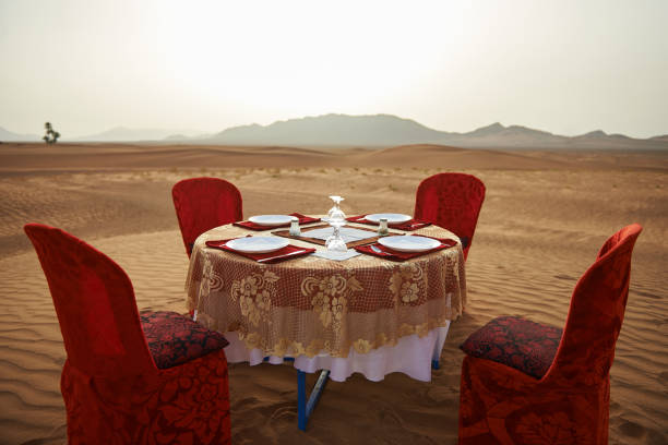A beautifully decorated dining table on top of a sand dune in the Sahara Desert.
