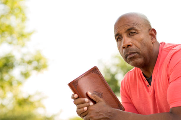 istock African American man praying and reading the Bible. 1169621921