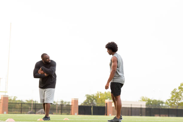 istock American Football coach training a young athlete. 1169624123