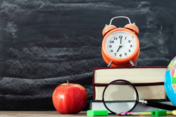 istock school stationery over wooden with blackboard background 1169624219