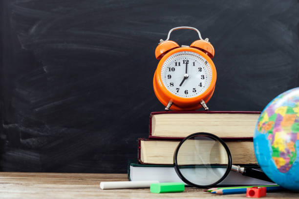 istock school stationery over wooden with blackboard background 1169624246
