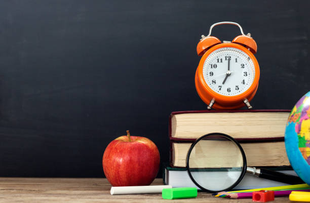istock school stationery over wooden with blackboard background 1169624248