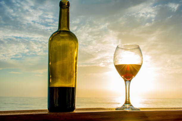 istock glass of wine and beach 1169629134