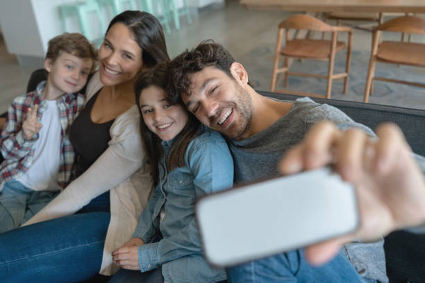 istock Happy family taking a selfie while relaxing at home very cheerfully 1169630566
