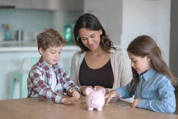 nette kinder zählen geld nach dem öffnen ihrer sparschwein mit ihrer mutter zu hause - currency savings coin counting stock-fotos und bilder