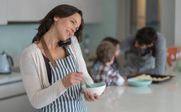 istock Beautiful mother multi tasking mixing something in bowl while on a phone call 1169630855