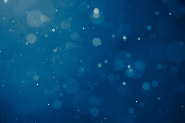 istock blue light background with snowflakes particles 1169632281