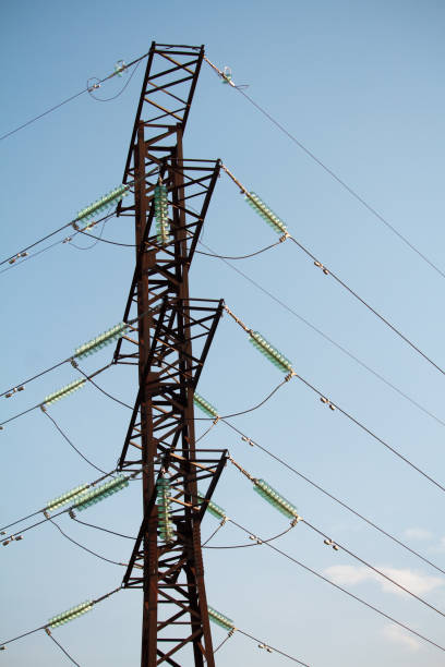 istock Bottom view on high voltage power lines against the blue cloudless sky 1169632995