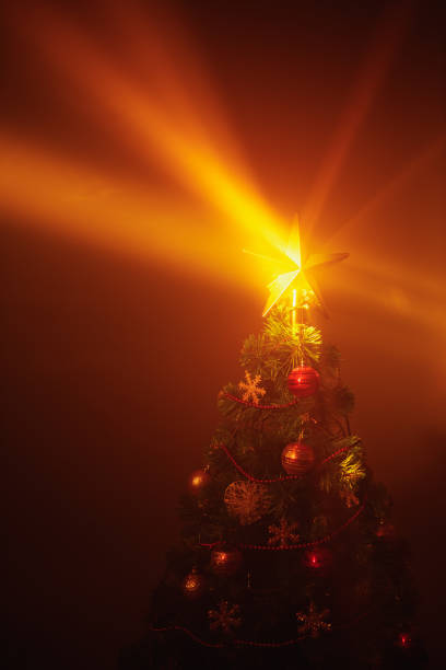 istock Christmas tree with festive lights in smoke 1169633058