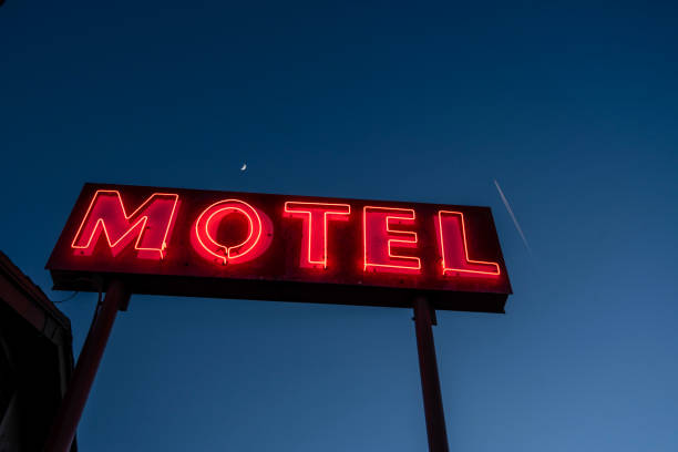 motel au néon illuminé signe ntre le ciel bleu foncé de lettres foncées - motel photos et images de collection