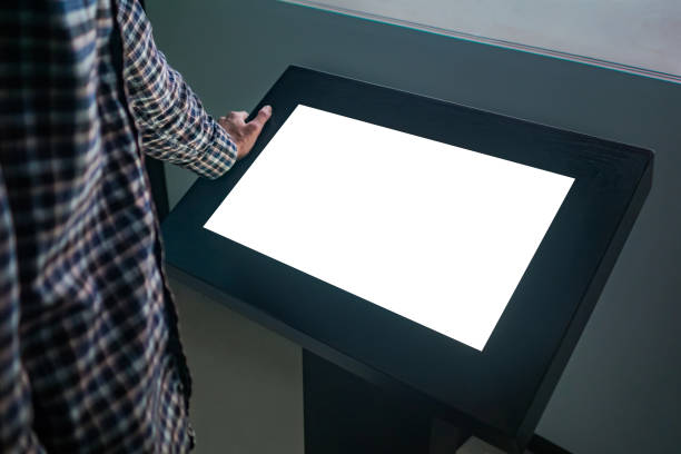 istock Mockup image - man looking at white blank touchscreen display kiosk 1169638250