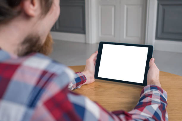 istock Man holding black digital tablet device with white blank screen - mockup image 1169638287