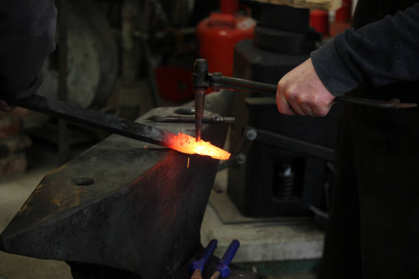 istock Blacksmith works with melting glowing Metal on Anvil 1169640690