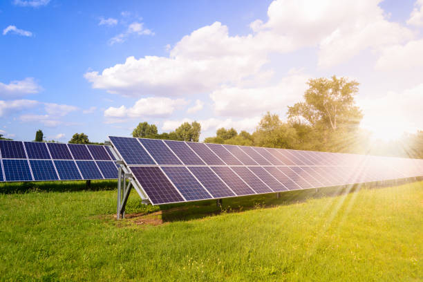 istock Solar panels mounted on the ground. Green grass and sunny blue sky background 1169642084