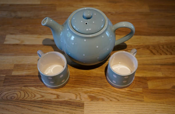 istock Two cups and a tea pot on a wooden background 1169642198