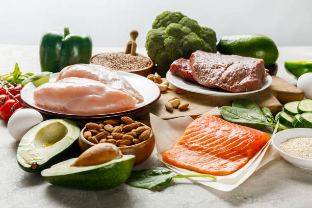 生のサーモン、肉、鶏の胸肉は、灰色のケト原性のダイエットメニューに分離された緑色の野菜の近くに - 不健康な食事 ストックフォトと画像