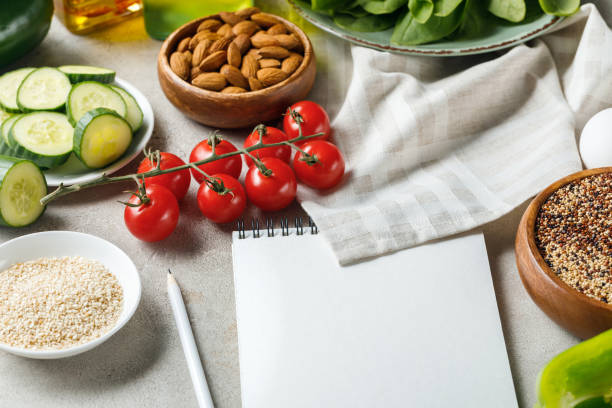 istock empty notebook with pencil on grey textured surface near napkin, nuts, tomatoes and cucumber, ketogenic diet menu 1169647834