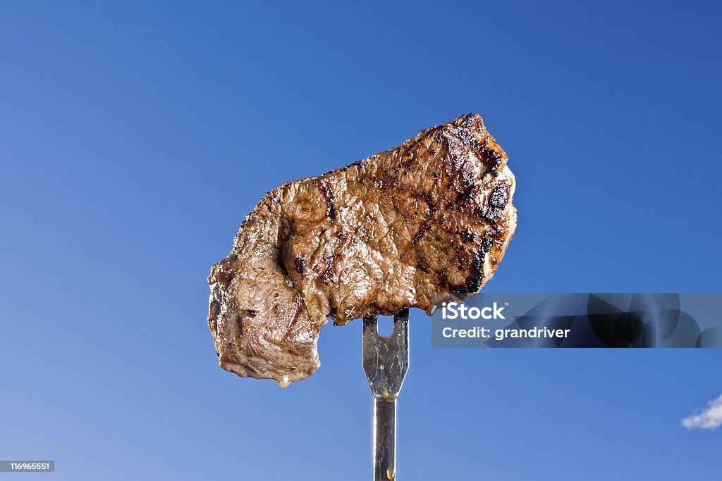 Bistec en un tenedor - Foto de stock de Bistec libre de derechos