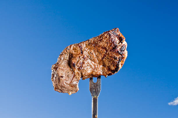 bistecca di manzo sulla forcella - broiling foto e immagini stock
