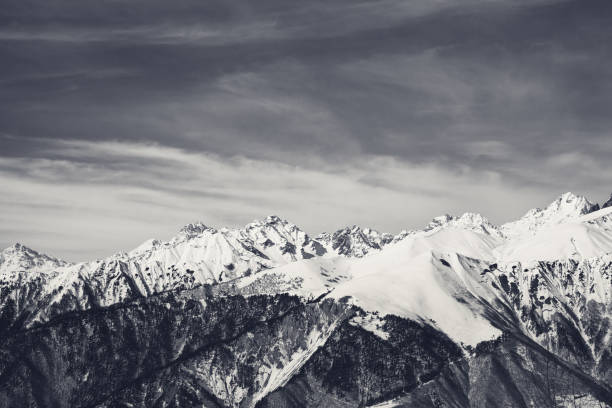 istock Sunlight snowy mountains and sky with clouds in sunny day 1169656232