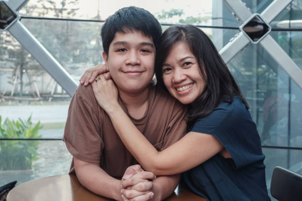 ritratto di stile di vita di madre e figlio asiatici che abbracciano e trascorrono del tempo insieme in un caffè urbano - brown boy foto e immagini stock