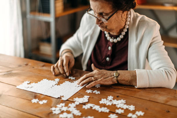 istock Old woman playing puzzle game 1169664152