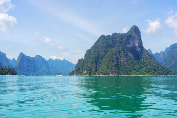 istock Limestone mountain in lake with mountain range and sky background 1169666350