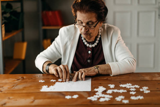 istock Old woman playing puzzle game 1169667493