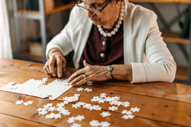 istock Old woman playing puzzle game 1169668374