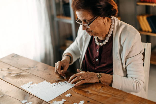 istock Old woman playing puzzle game 1169669234