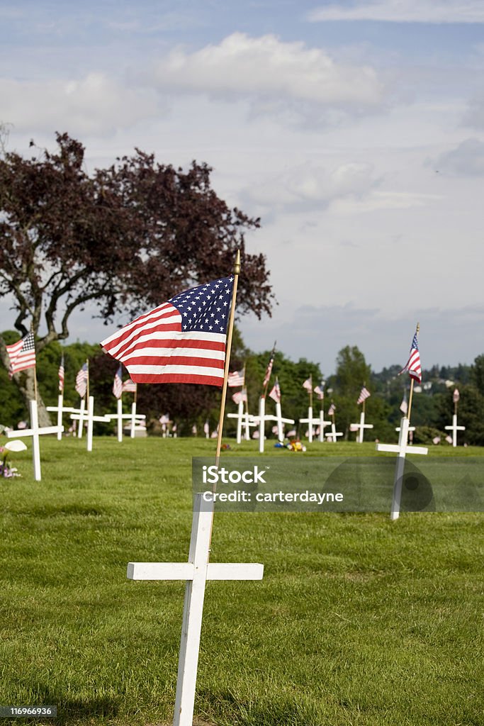 Memorial with white cross and US flag Memorial day graveyard with white crosses and the US flag.   American Flag Stock Photo