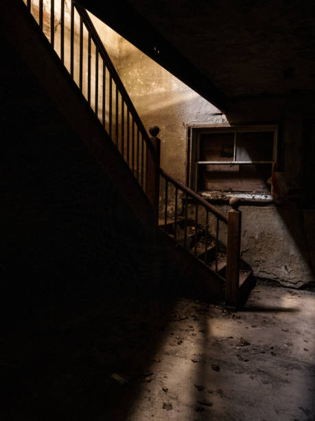 Mystical horror scary garret background to halloween. Old antique dirty wooden staircase in the dark in a mysterious paranormal spooky basement or attic with black shadow in the blue light of the moon