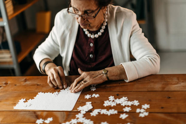 istock Old woman playing puzzle game 1169672807