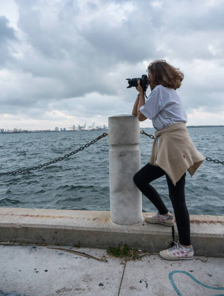 istock Woman with camera shooting fantastic landscape 1169674523