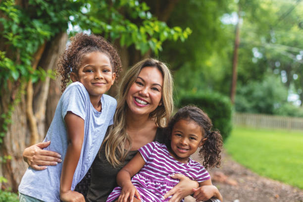 madre china asiática con dos hijas de etnia mixta china y afroamericana en un entorno verde exuberante patio trasero posando para retratos sonriendo y siendo tonto - acogida temporal fotografías e imágenes de stock