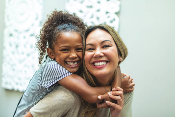 madre asiática con hija de etnia mixta china y afroamericana en casa en el interior posando juguetonamente para retratos sonriendo y siendo tonto - acogida temporal fotografías e imágenes de stock