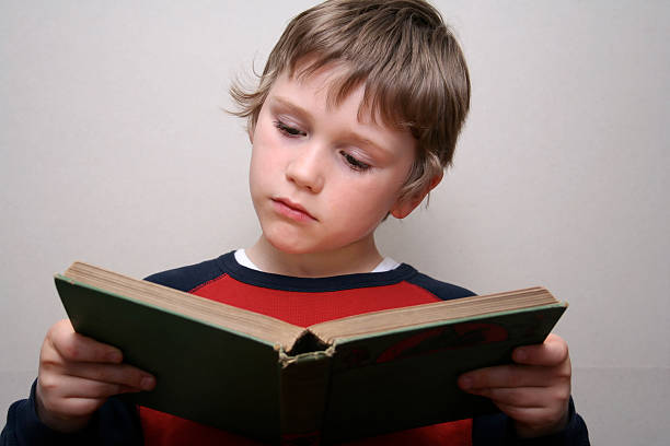 istock Little boy concentrating on reading an antique Victorian book 116968566