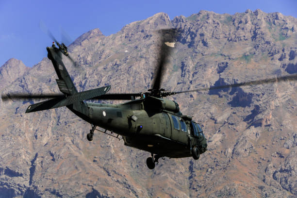 istock Military Utility Helicopter flying against mountain 1169690060