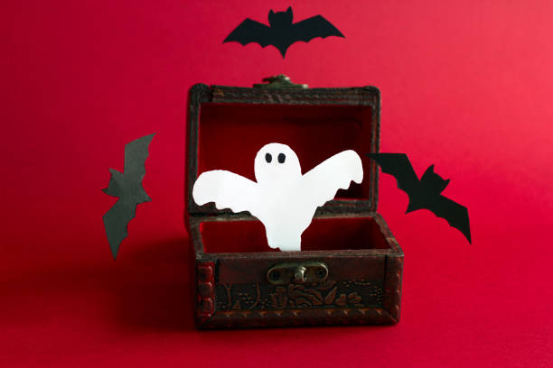 paper cut scary ghost and bats fly out of an old vintage wooden chest on a black background paper cut scary ghost and bats fly out of an old vintage wooden chest on a black background, festive Halloween card child casket stock pictures, royalty-free photos & images