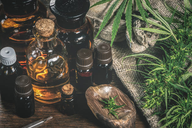 CBD oil. CBD oil bottles and green plant of cannabis on a wooden background. Herbal medicine. narcotic photos stock pictures, royalty-free photos & images
