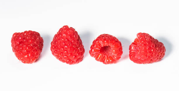 istock a line of four fresh raspberries on white 1169694640