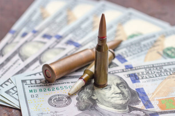 waffengeschosse auf us-dollar hintergrund. militärindustrie, krieg, globaler waffenhandel und verbrechenskonzept. - currency crime gun conflict stock-fotos und bilder
