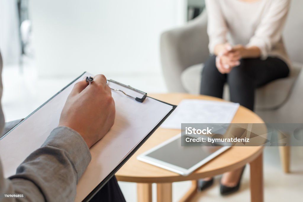 Psychologist understanding problems of a woman patient Mental Health Professional Stock Photo