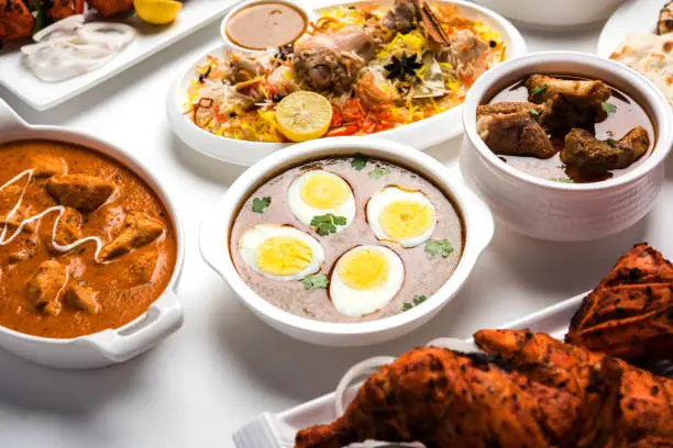 Photo of Assorted Indian Non Vegetarian food recipe served in a group. Includes Chicken Curry, Mutton Masala, Anda/egg curry, Butter chicken, biryani, tandoori murg, chicken-tikka and naan/roti
