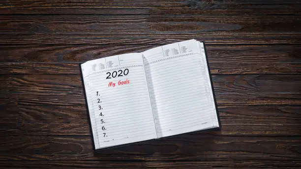 list goals. Concept: setting goals for 2020. Open notebook with a blank page and the caption MY GOALS 2020.