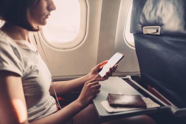 istock Young woman on a plane with a smartphone in her hands 1169698857