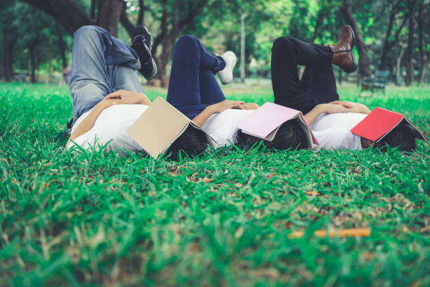 istock Funny students sleeping with books covering their face. Lazy and relaxation concept. 1169701144