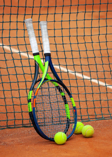 istock Tennis rackets and balls leaned against the net. 1169701228