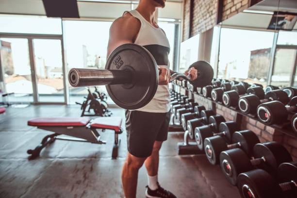 istock Strong powerful bodybuilder is doing his workout with barbell in gym 1169703804